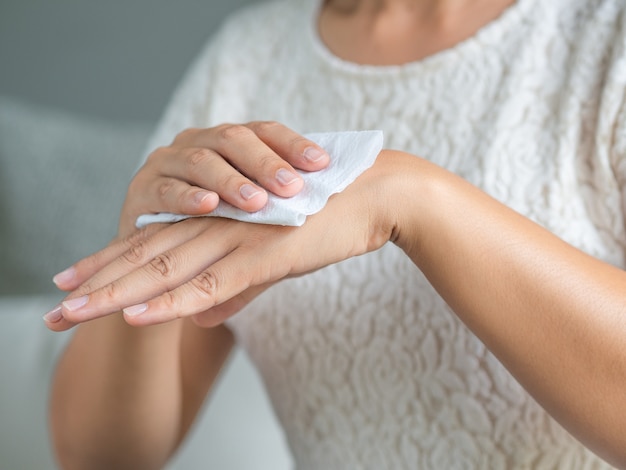 Femme nettoyant ses mains avec un mouchoir