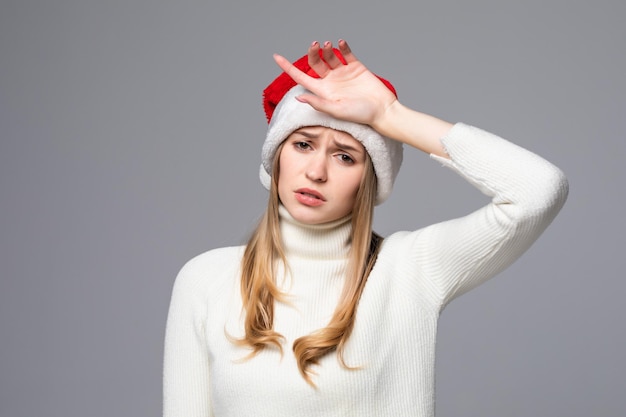 Femme de Noël offensée en bonnet de Noel isolé sur un mur gris