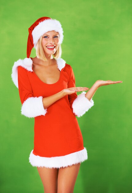 Photo femme noël et paume en studio avec sourire pour une célébration de vacances festives ou un événement cadeau femme chapeau de père noël et visage sur fond vert maquette pour un cadeau de promotion ou des ventes présentes