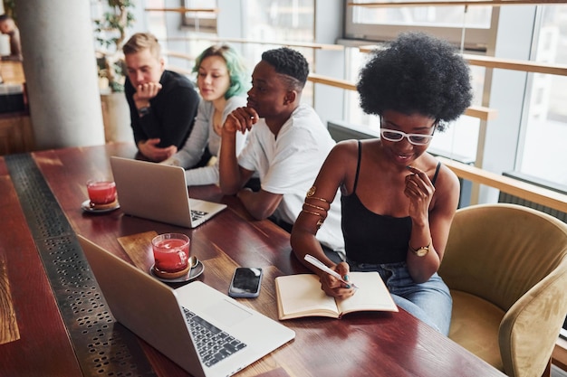 Une femme noire assise devant un groupe de personnes multiethniques
