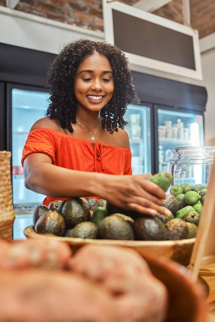 Femme noire au supermarché épicerie et client d'avocat et produit frais de légumes au détail et achat de nourriture au magasin Jeune afro-américain et sourire vente et remise sur l'épicerie