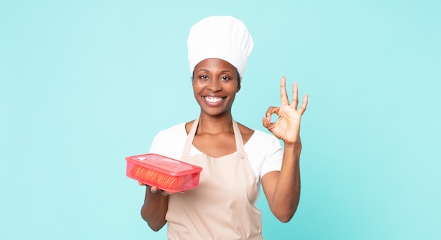 femme noire de chef d'adulte d'afro-américain avec un tupperware