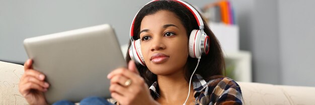 Une femme noire concentrée qui étudie une langue étrangère en ligne