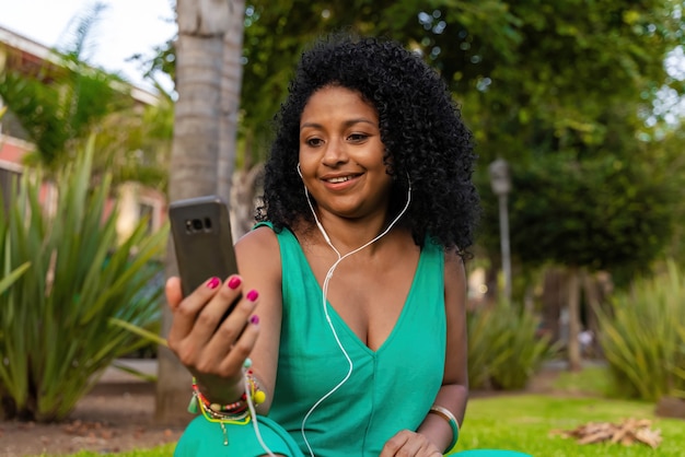 Femme noire dans le parc avec appel vidéo