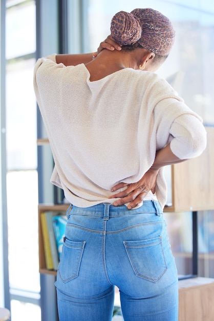 Photo femme noire douleur au dos et au cou dans le stress fatigué ou surchargé de travail à la maison femme afro-américaine souffrant d'inconfort de tension musculaire ou de douleur dans l'épuisement professionnel ou de problèmes de santé mentale