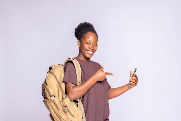 Une femme noire excitée pointe son doigt sur son smartphone en recommandant une application mobile