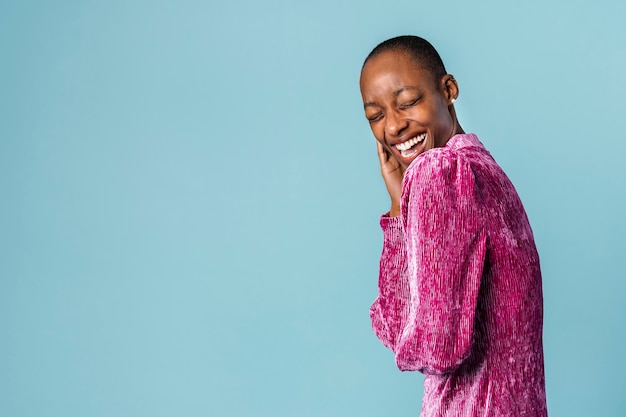 Femme noire gaie dans une robe rose