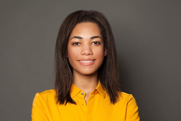 Une femme noire intelligente et positive souriant et regardant la caméra visage féminin portrait en gros plan