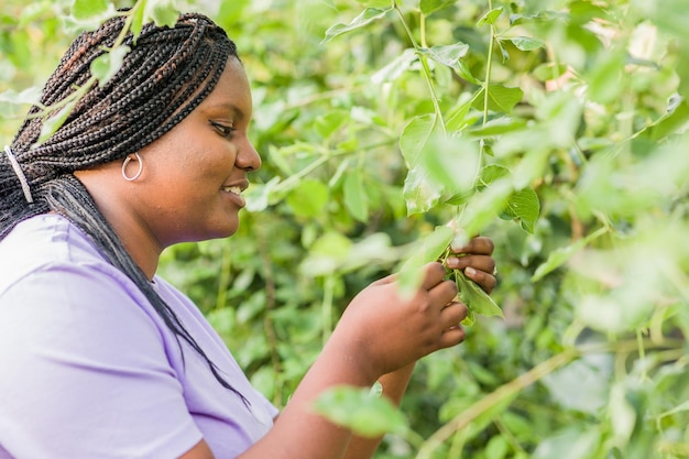 Femme noire latine cubaine jardinant dans un jardin urbain horticulture durable avec des aliments biologiques