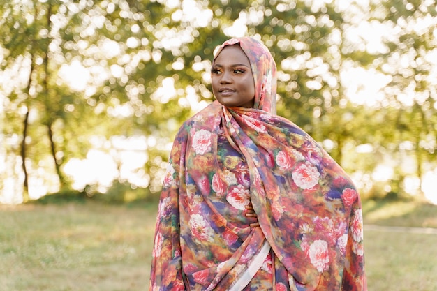 Femme noire musulmane ethnique africaine portait des sourires hijab colorés traditionnels sur le pré vert