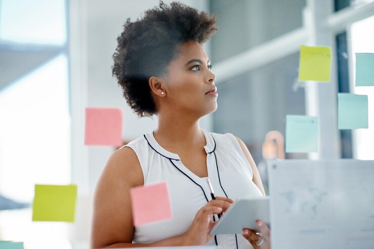Photo femme noire pensant ou brainstorming sur tablette de verre mur ou note collante pour la planification de l'horaire au bureau recherche de solution ou concepteur en démarrage pour des idées résolution de problèmes ou projet créatif