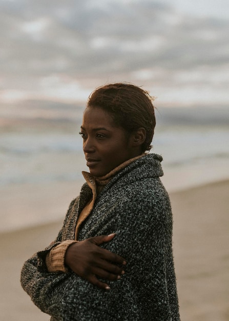 Femme noire sur la plage au coucher du soleil