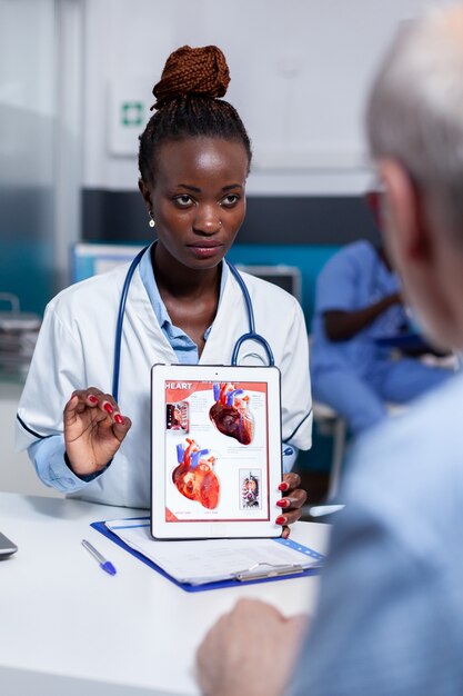 Femme noire avec la profession de docteur montrant l'illustration d'organes