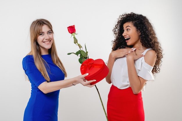 Femme noire recevant un cadeau de Saint Valentin en forme de coeur et rose de petite amie isolée