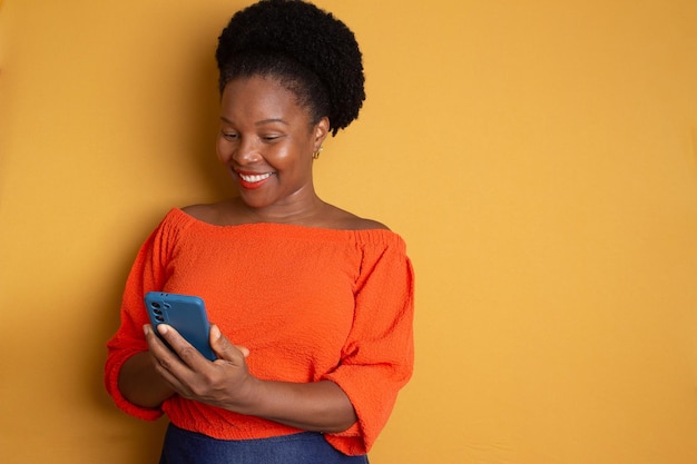 une femme noire regardant un smartphone