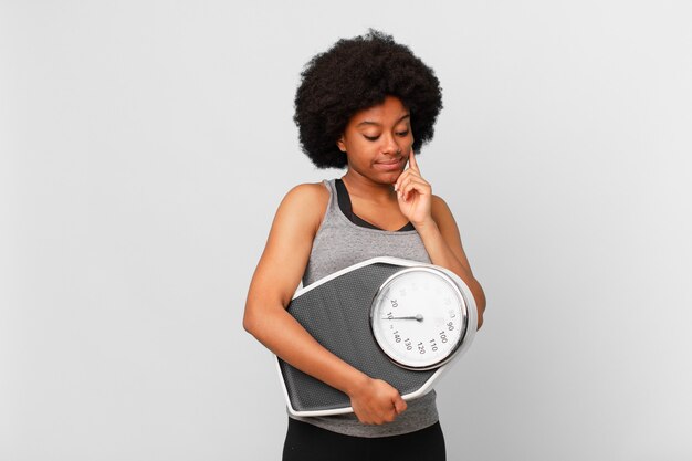 Femme noire de remise en forme afro avec une balance ou une balance