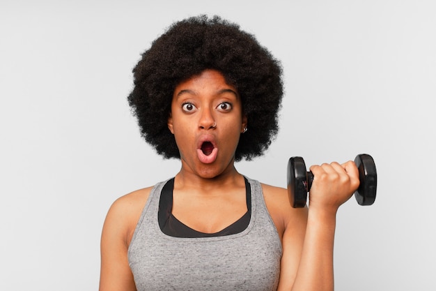 Femme noire de remise en forme afro avec un haltère