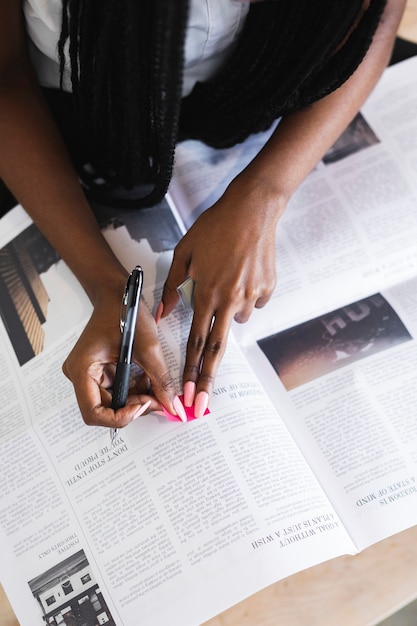 Femme noire soulignant un article sur le journal