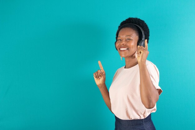 femme noire souriant et écoutant une chanson avec un fond vert