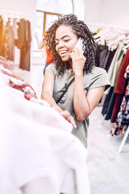 Femme noire souriante, parler téléphone, dans, magasin