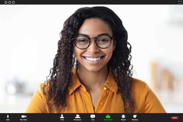 Femme noire souriante portant des lunettes ayant un chat vidéo