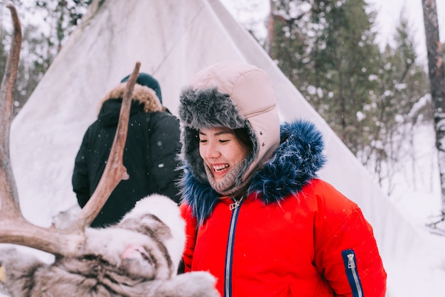 Femme nourrir un renne en hiver