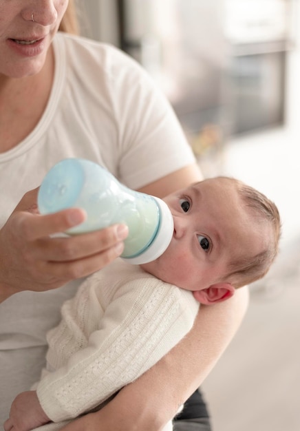 Femme nourrissant le nouveau-né avec du lait pour bébé nutrition artificielle amour et chaleur de la mère