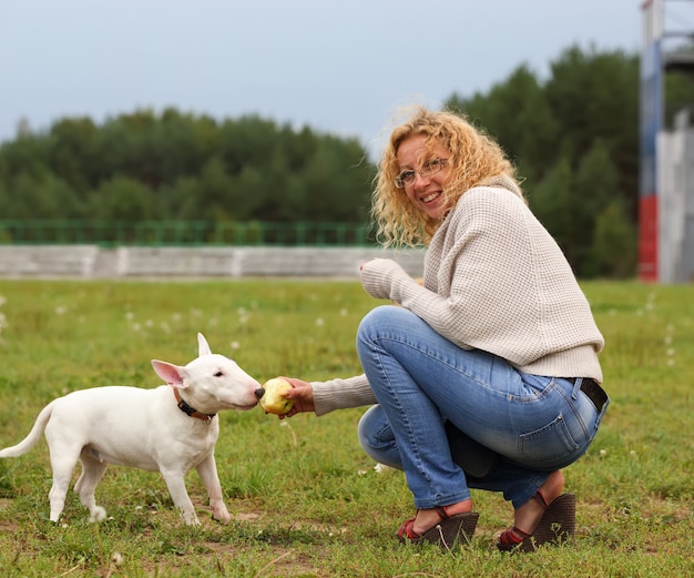 Une femme nourrit un chien un os