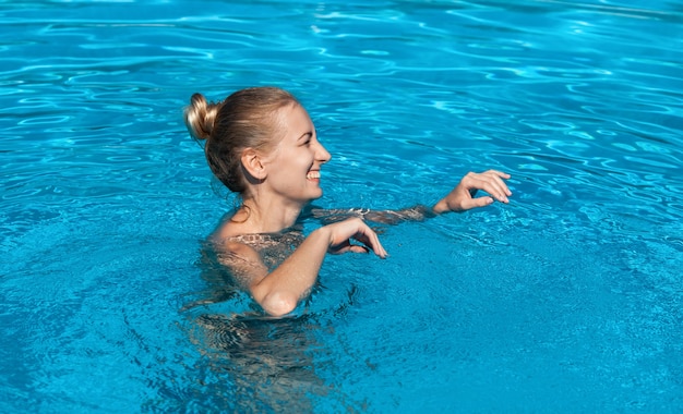 Femme nue à l'extérieur. Belle jeune femme nue dans la piscine. Jeune blonde nue nage dans la piscine extérieure