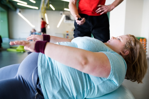 Femme obèse exerçant sur ballon de fitness