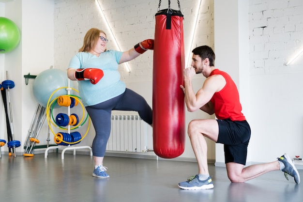 Femme obèse travaillant avec un entraîneur