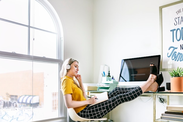 Femme occasionnelle dans un bureau avec des écouteurs