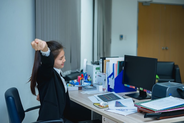 Femme officier asiatique qui s'étend du corps au bureau du bureau de l'angle arrière