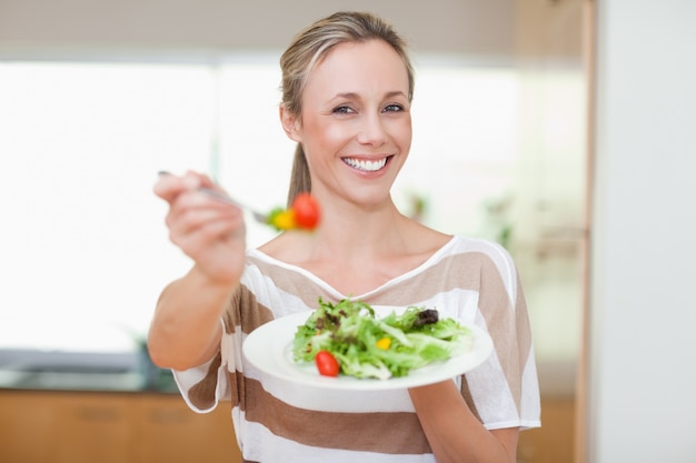 Femme offrant une salade saine