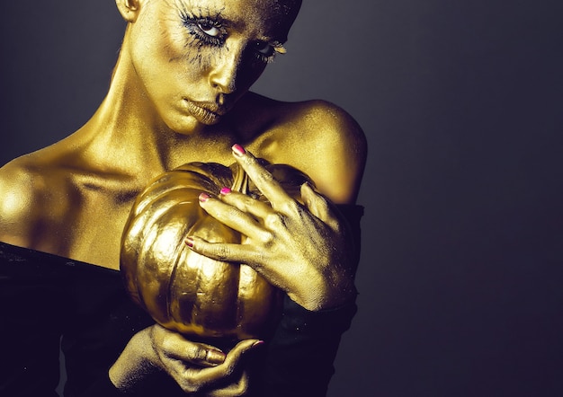 Femme d'or avec citrouille d'halloween