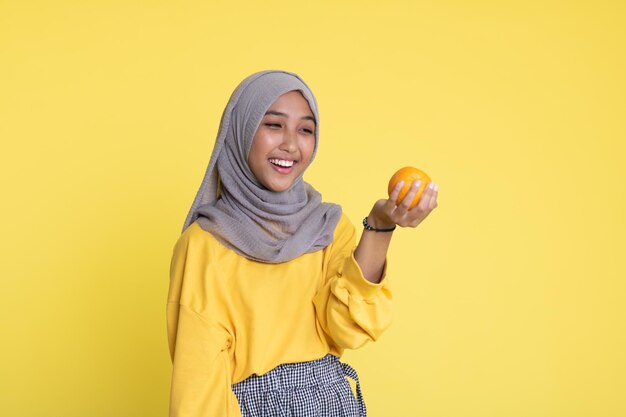 femme avec orange sur fond jaune