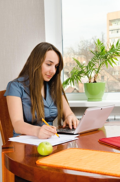 Femme avec ordinateur assis à la table