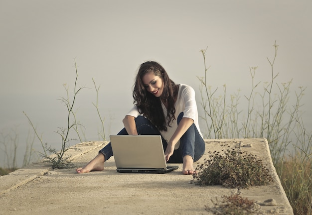 Femme avec un ordinateur portable dans la nature