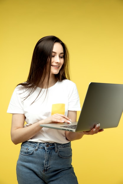 femme avec ordinateur portable sur fond jaune