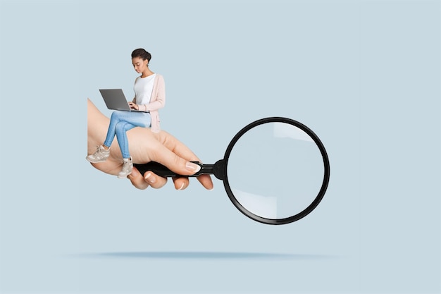 Une femme avec un ordinateur portable et une grosse main avec une loupe.