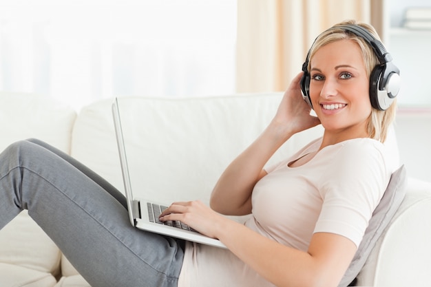 Femme avec un ordinateur portable et des headhones