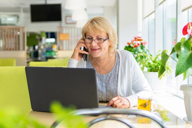 Femme avec un ordinateur portable travaille dans un café au bureau, elle est pigiste