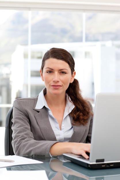 Femme sur l&#39;ordinateur en regardant la caméra