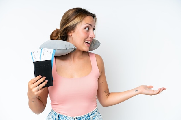 Femme avec oreiller de voyage gonflable sur fond isolé avec expression de surprise tout en regardant de côté