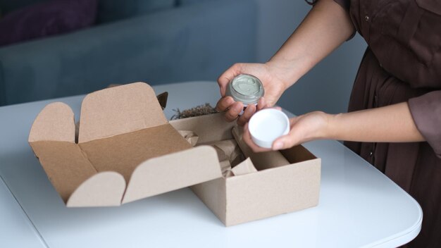 femme ouvrant et déballant un colis dans une boîte en carton