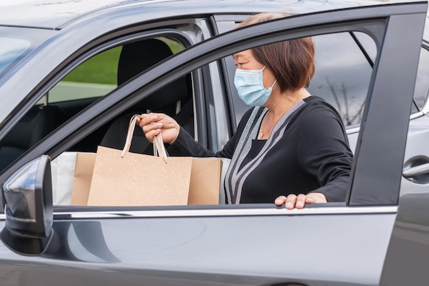Une femme ouvre la porte de la voiture.