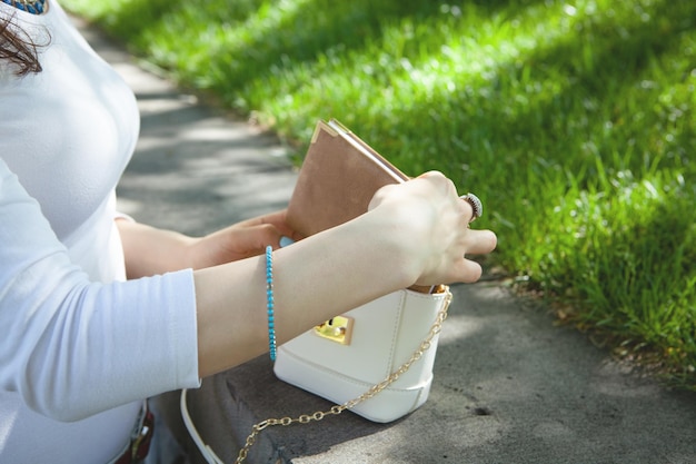 La femme ouvre son sac à main en parc