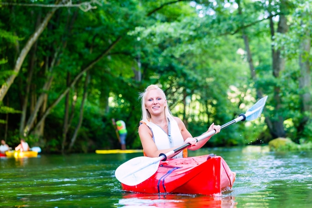 Femme Pagayer Avec Canoë Sur La Rivière Forestière En été