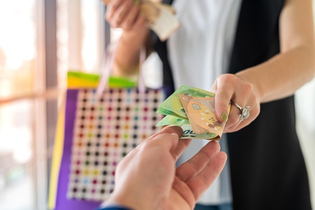 la femme paie de l'argent en euros en achetant des vêtements dans le magasin. concept de magasinage. vendredi noir