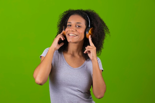 Une femme avec une paire d'écouteurs et un fond vert.